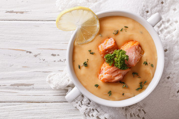 Salmon cream soup with lemon on the table. horizontal top view
