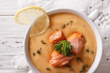 Salmon cream soup closeup on the table. horizontal top view
