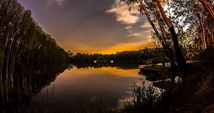 Night time-lapse of a lake with wakeboarding obstacles.