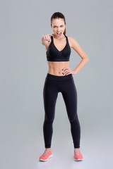 Fototapeta na wymiar Mad angry fitness woman screaming and pointing on you