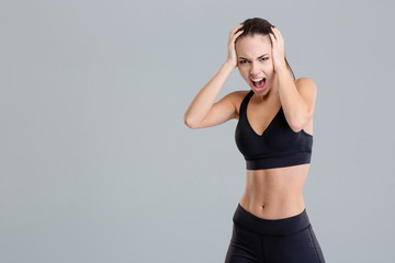 Fototapeta na wymiar Crazy hysterical shouting fitness girl in black top and leggings