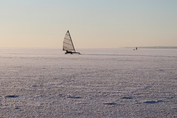 The iceboat sliding on a surface of the frozen river in the winter