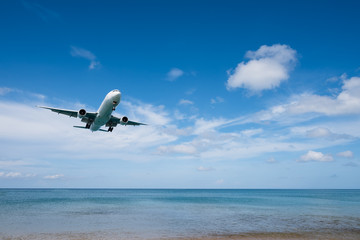Fototapeta na wymiar Airplane landing from sea to airport