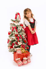 Bambina in piedi con albero di Natale e addobbi