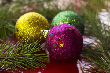 Beautiful colored shiny balls with holiday decorations close up on the red background