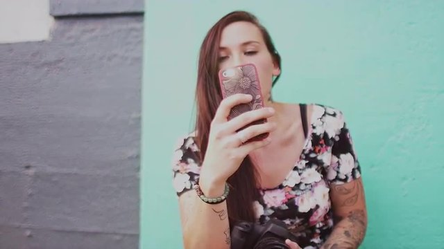 A beautiful girl taking pictures with her cell phone, slow motion
