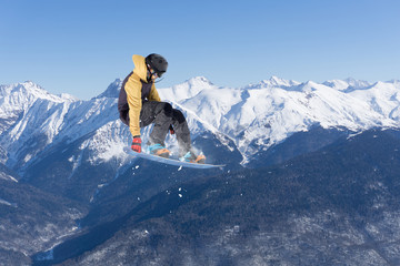 Flying snowboarder on mountains. Extreme sport.