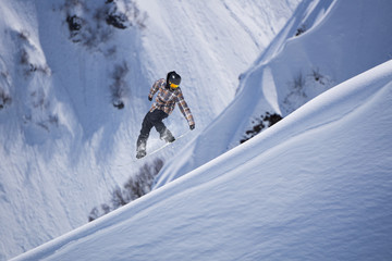 Flying snowboarder on mountains. Extreme sport.