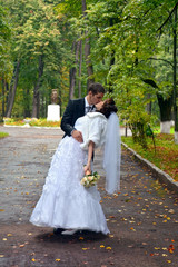 Happy wedding couple. Bride and Groom kissing in the park 