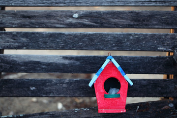 colorful bird house on wooden panel