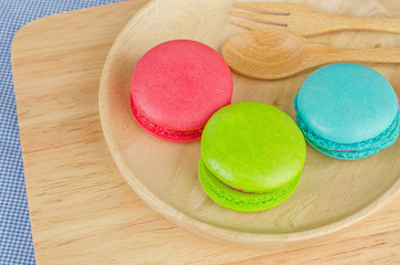 Tasty Sweet Macaroons on wooden background.