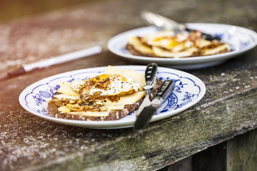 two plates with fried egg on an old table