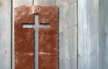 Old vintage Christian paper cross on wood background