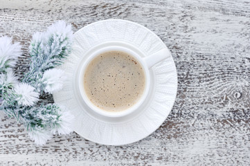 Cups of coffee and fir branches with frost on wooden table backg