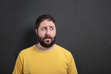 Astonished man looking at side. On dark chalk board