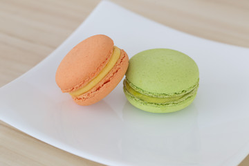 Macarons on wooden background.