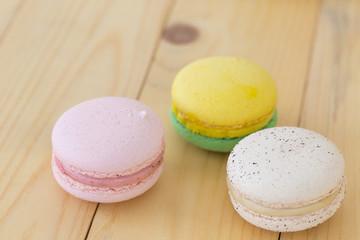 Colorful Macaroons boxset on wooden background.