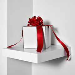 white gift box with a red satin ribbon
