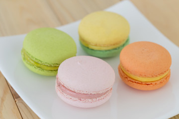 Colorful macarons on wooden background.