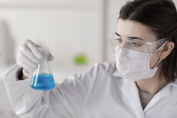 close up of scientist with flask making test