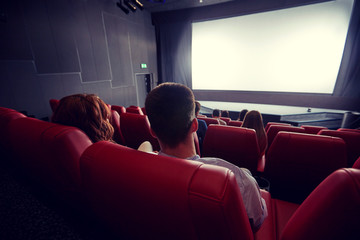 happy couple watching movie in theater or cinema - obrazy, fototapety, plakaty
