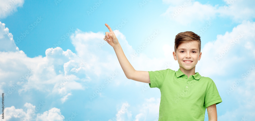 Poster happy boy in green polo t-shirt pointing finger up