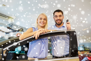 happy couple buying car in auto show or salon