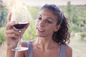 pretty girl looking glass of wine before drinking