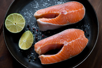 Two raw trout steaks in a frying pan ready to be cooked, closeup