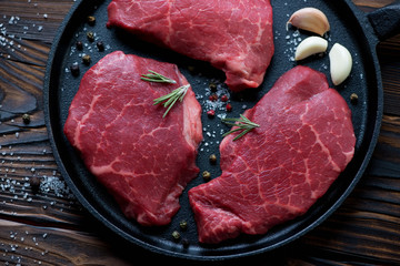Close-up of raw seasoned marbled beef steaks, above view