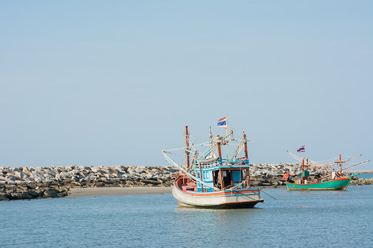 Two fishery boats floating on clam blue sea wity clear blue sky.