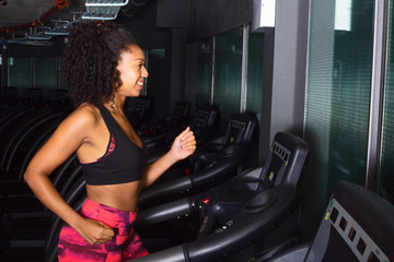 Fototapeta na wymiar young woman running on a treadmill at the gym
