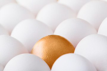 Background with many white and one gold egg