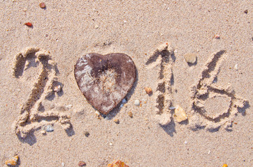 Happy New Year 2016 on the sand backgroung Texture and Heart-shaped coconut shell