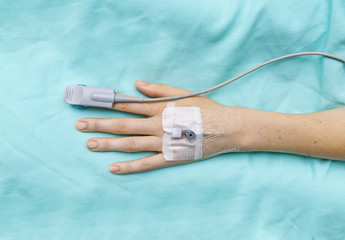 Hand of patient with oxygen saturation probe and intravenous line