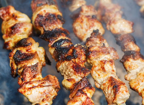Close up of grilling marinated shashlik. Skewered meat. Shallow depth of field. Selective focus.