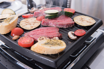 steaks, garlic bread and mushrooms on the raclette  cooking