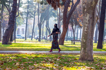 Young Muslim Woman walking in park