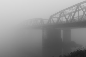 old iron bridge over wrapped in a mysterious fog