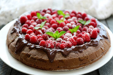 Cake with Chocolate Glaze and raspberries on wooden background