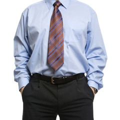 Businessman in blue shirt standing with hands in pockets