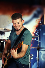 Young man playing on electric guitar at pub