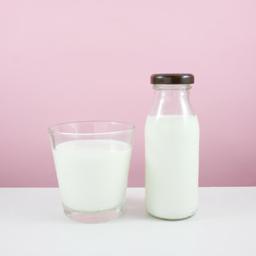 The glass and bottle of fresh milk on the white table.