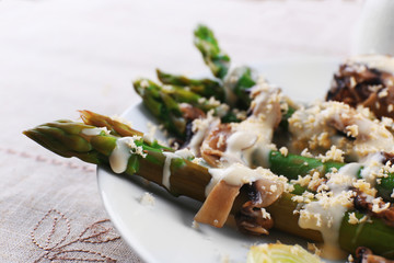 Appetizing dish with asparagus and mushrooms on served table in the restaurant