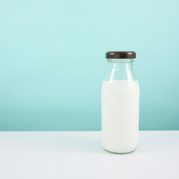 The bottle of fresh milk on the white table.
