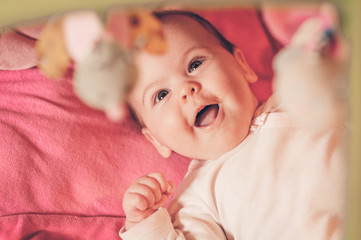 Happy baby playing with hanging toys