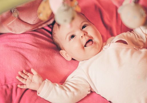Happy baby playing with hanging toys