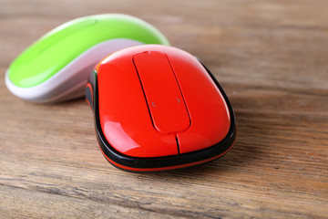 Wireless computer mouses on wooden background