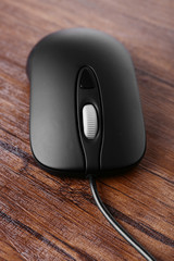 Computer mouse with cord on wooden background