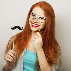 Young woman wearing fake mustaches. 